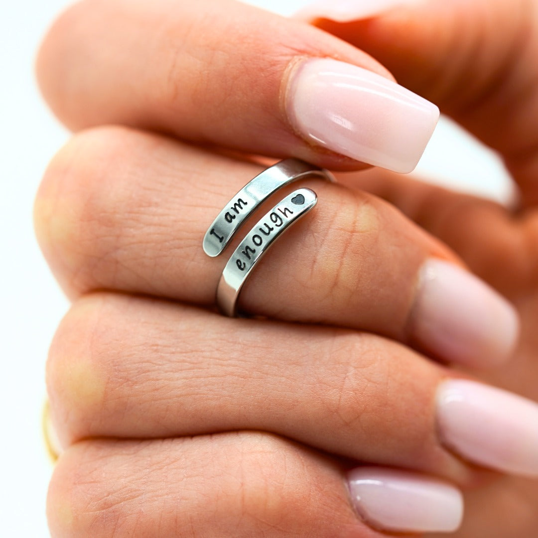 I Am Enough ring worn on a finger