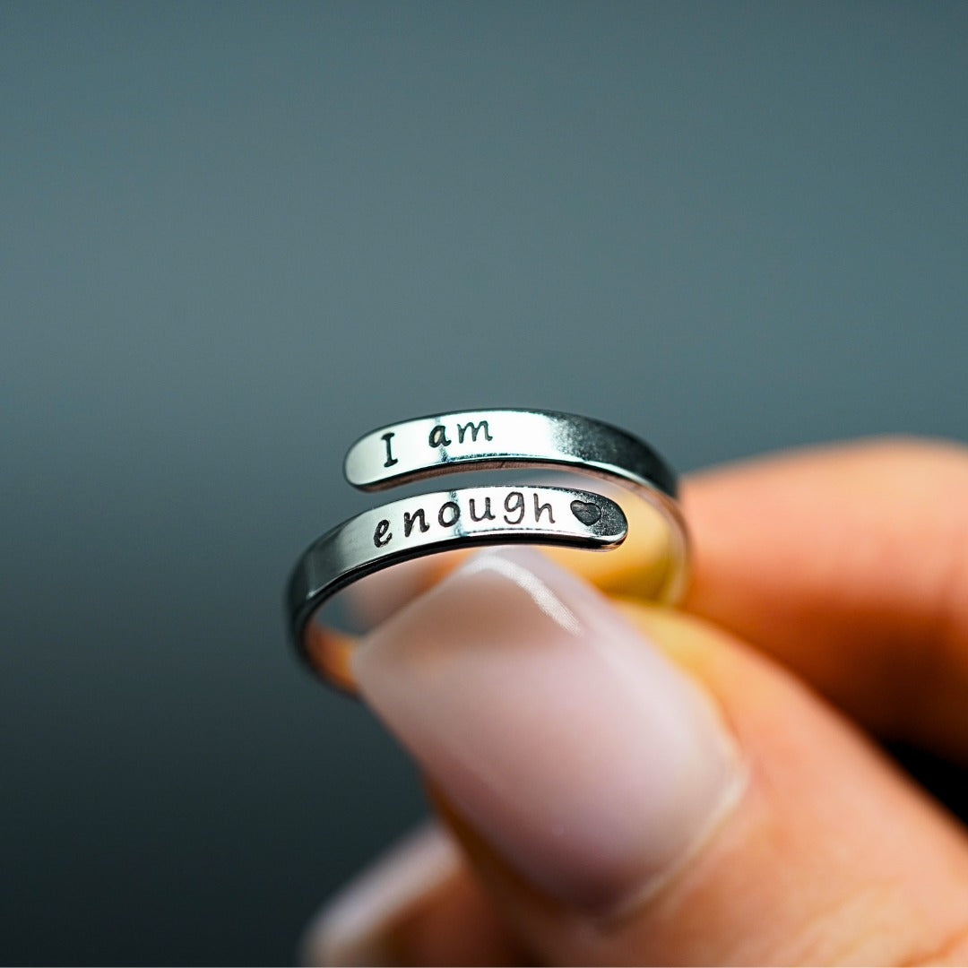 I Am Enough ring held against a dark background